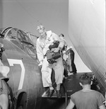 US Navy photographer Lieutenant Charles Kerlee dismounting a TBF Avenger aboard USS Yorktown (Essex-class) after photographing a raid on Wake Island, 6 Oct 1943. Note his two K-20 cameras.